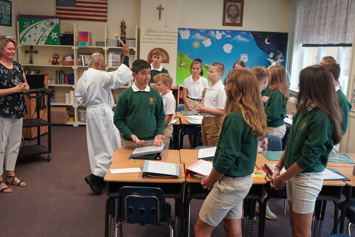 Father Alexander Gabriel, pastor of Holy Family Parish in Hannibal and St. Joseph Parish in Palmyra, blesses the eighth-grade classroom and its students on the first day of school at Holy Family School in Hannibal. He would visit all the classrooms, pray with the students and sprinkle them with holy water.